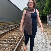 Outdoor portrait of Catherine Moore standing next to railroad track
